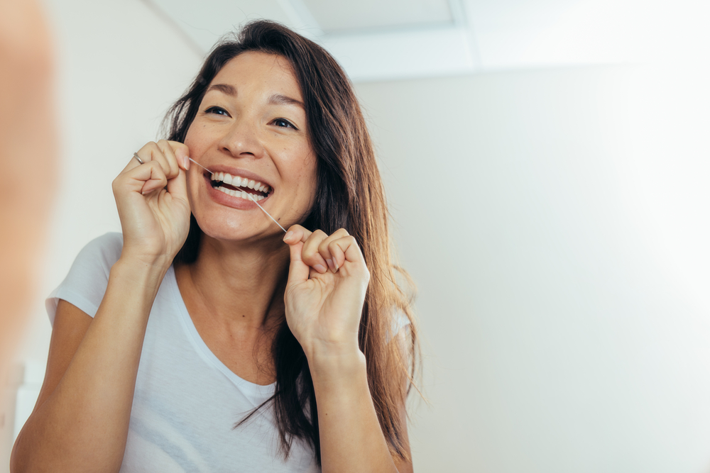woman flossing for healthy teeth
